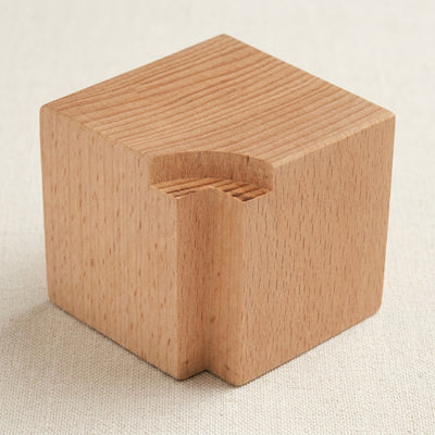Wooden block for holding jewellery stamps securely during metal marking.