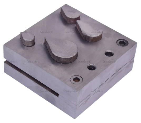 Close-up of the four steel teardrop punch dies showing their smooth internal finish.