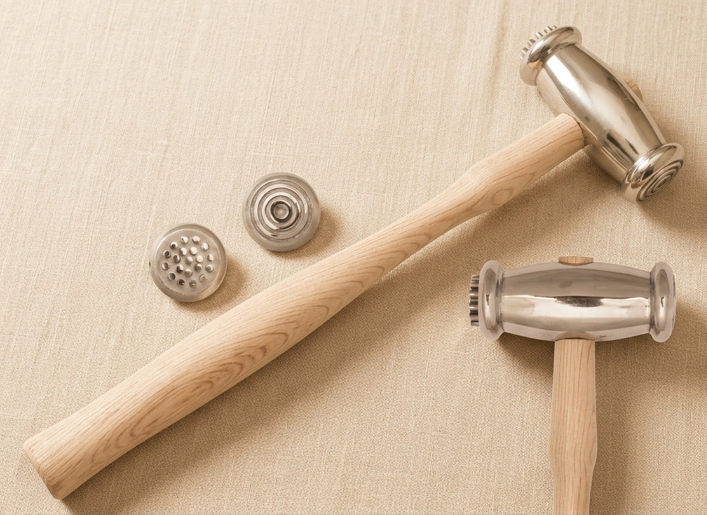 Close-up showing the wide circle and dot texturing faces of the dual-headed jewellery hammer.