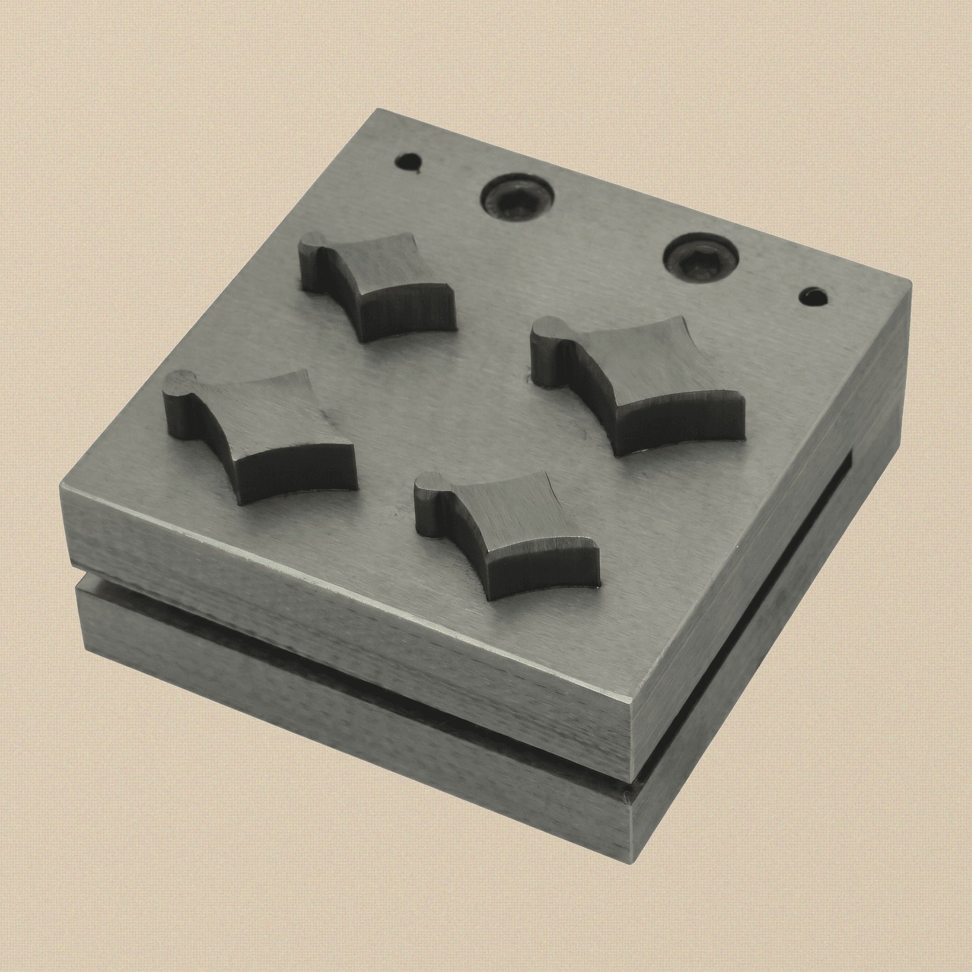 Kite shape disc cutter set with four punches arranged next to the steel die block.