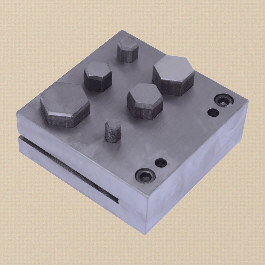 Close-up of the six hexagon-shaped apertures in the hardened steel die block.