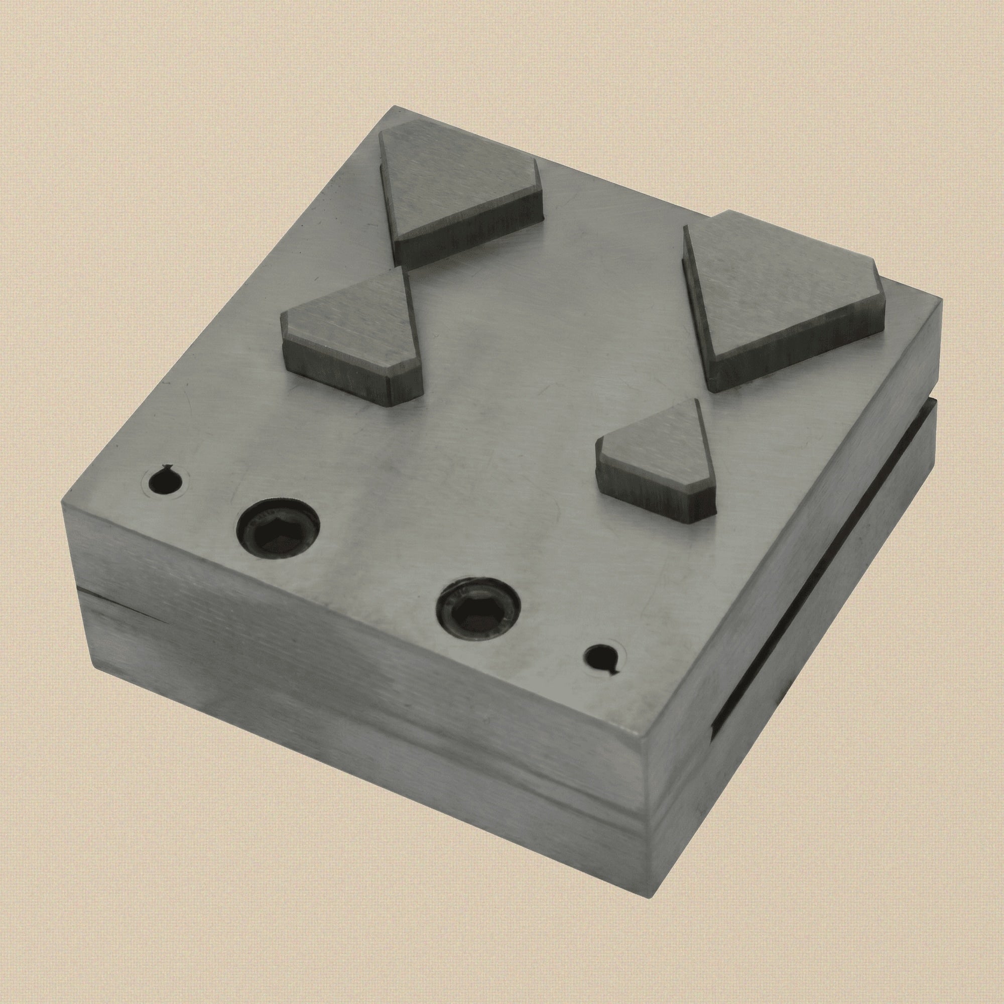 Close-up of the four diamond-shaped apertures in the steel die block.