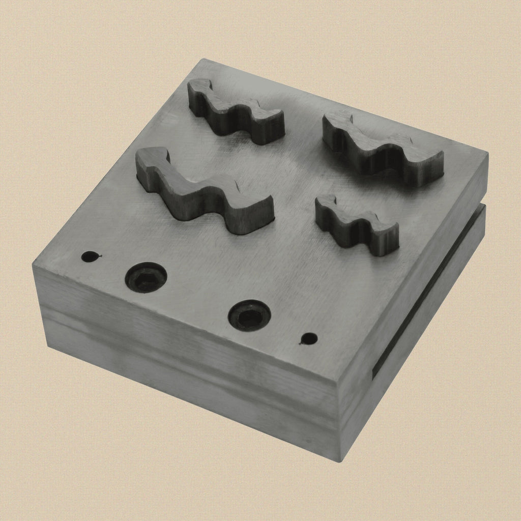 Close-up of the four snake-shaped punches showing the different sizes and cutting edges.