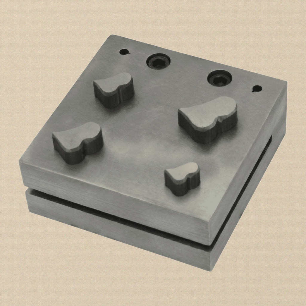 Close-up of the four wide heart-shaped cutting holes in the steel disc cutter block.