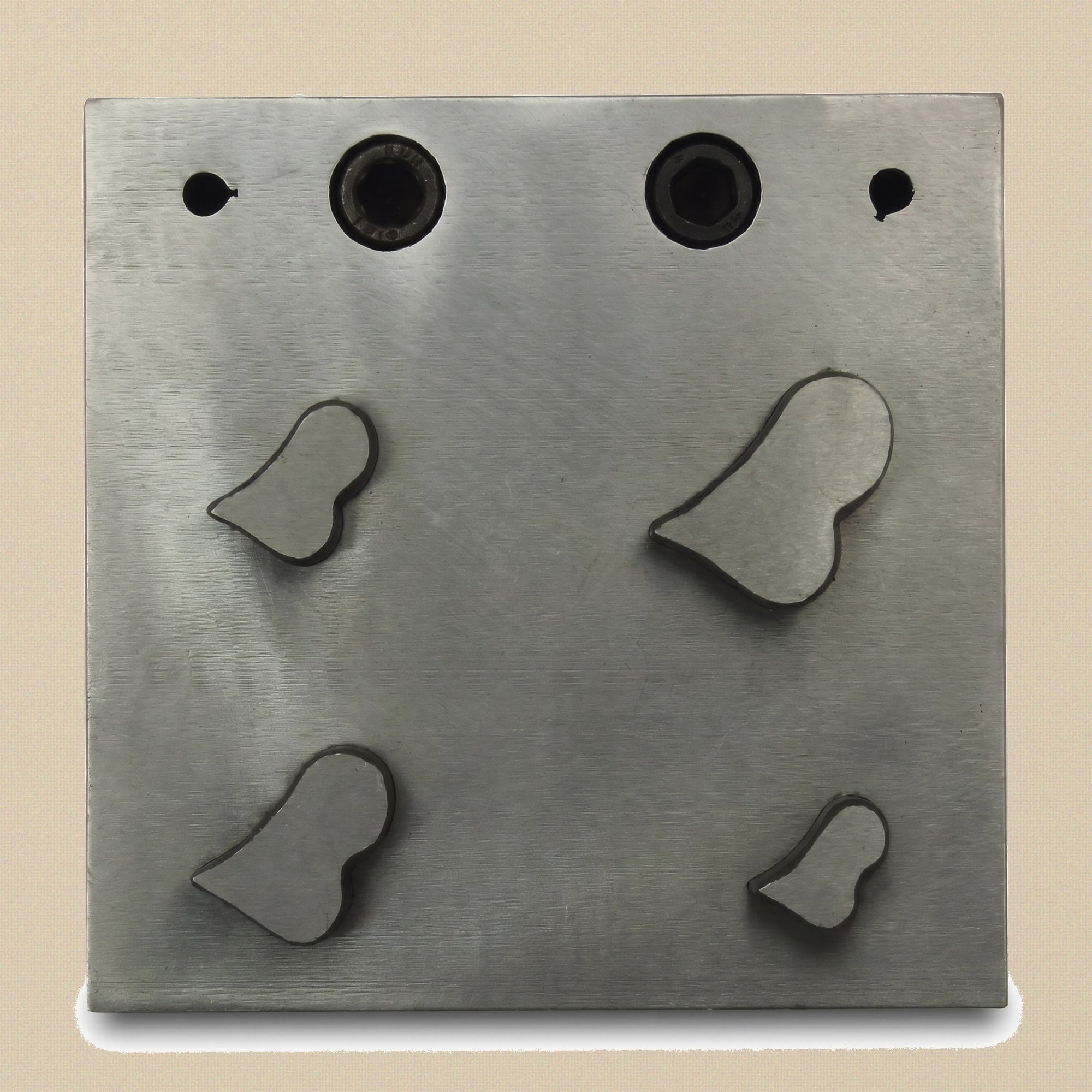 The four hardened steel punches showing the sharp cutting ends and beveled striking ends.