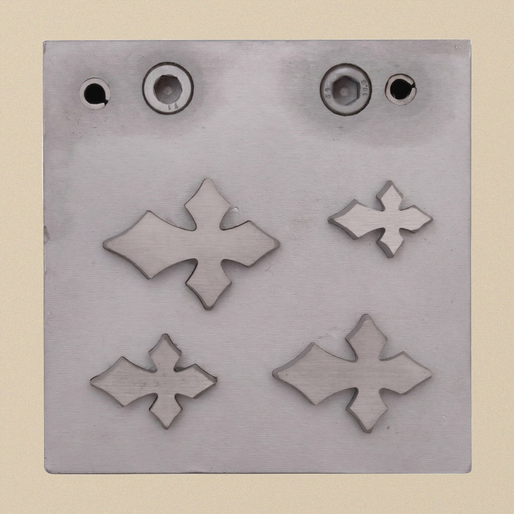 The steel die block for the Gothic Cross cutter, showing the four precision-cut apertures.