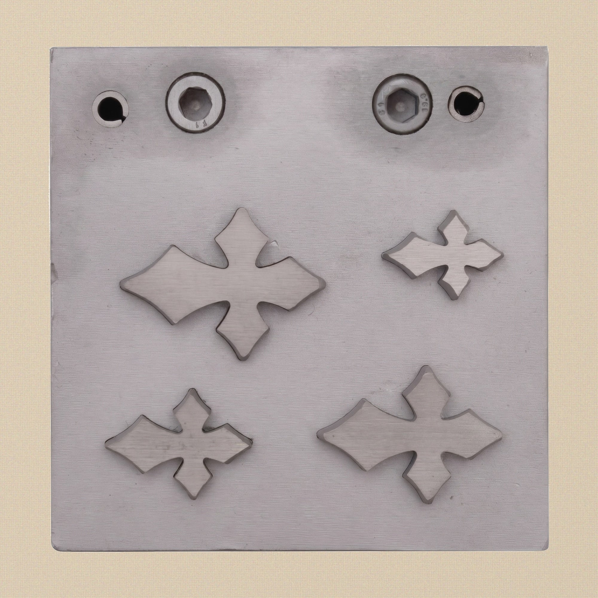 The steel die block for the Gothic Cross cutter, showing the four precision-cut apertures.