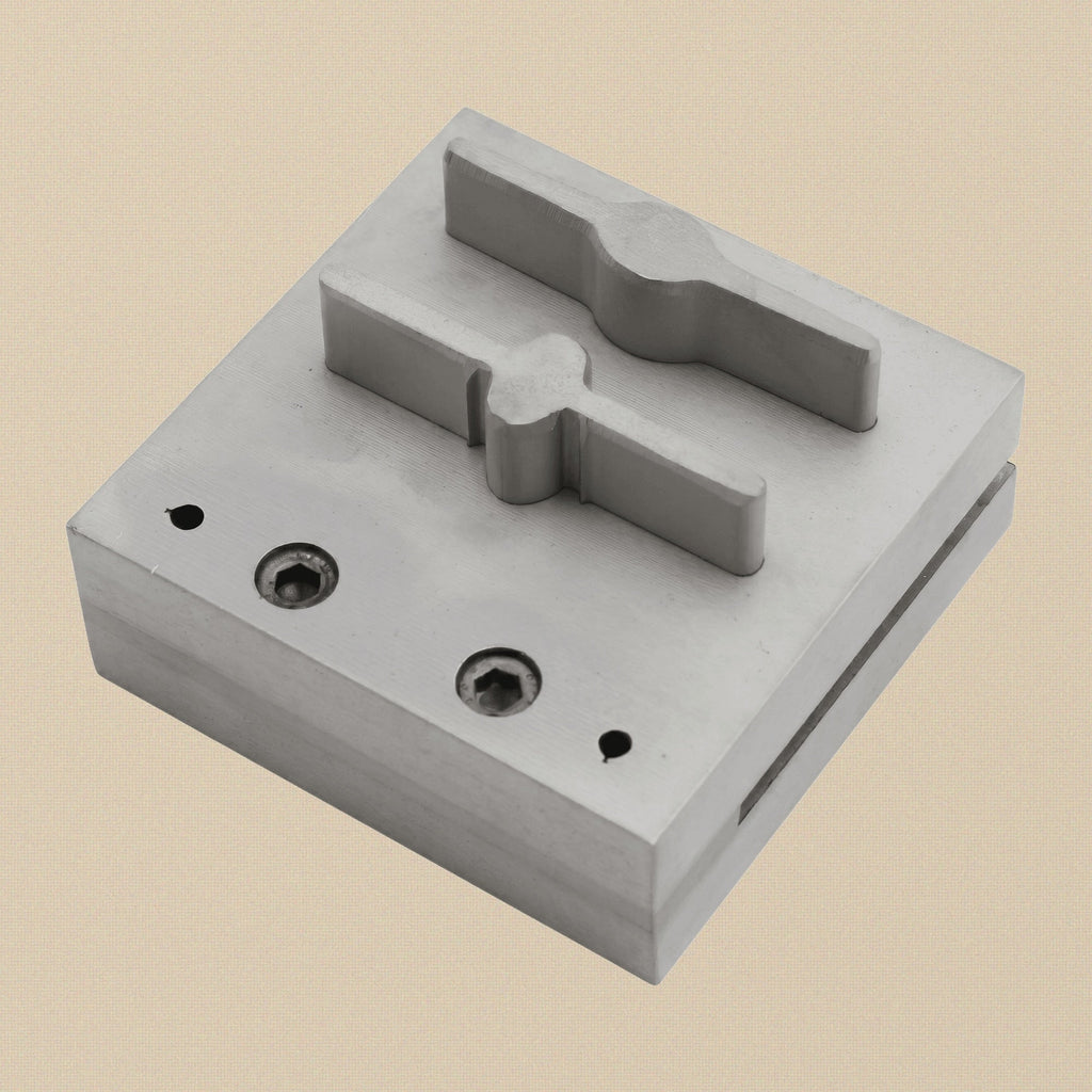 The two hardened steel punches, one bar-shaped and one paddle-shaped, showing cutting and striking ends.