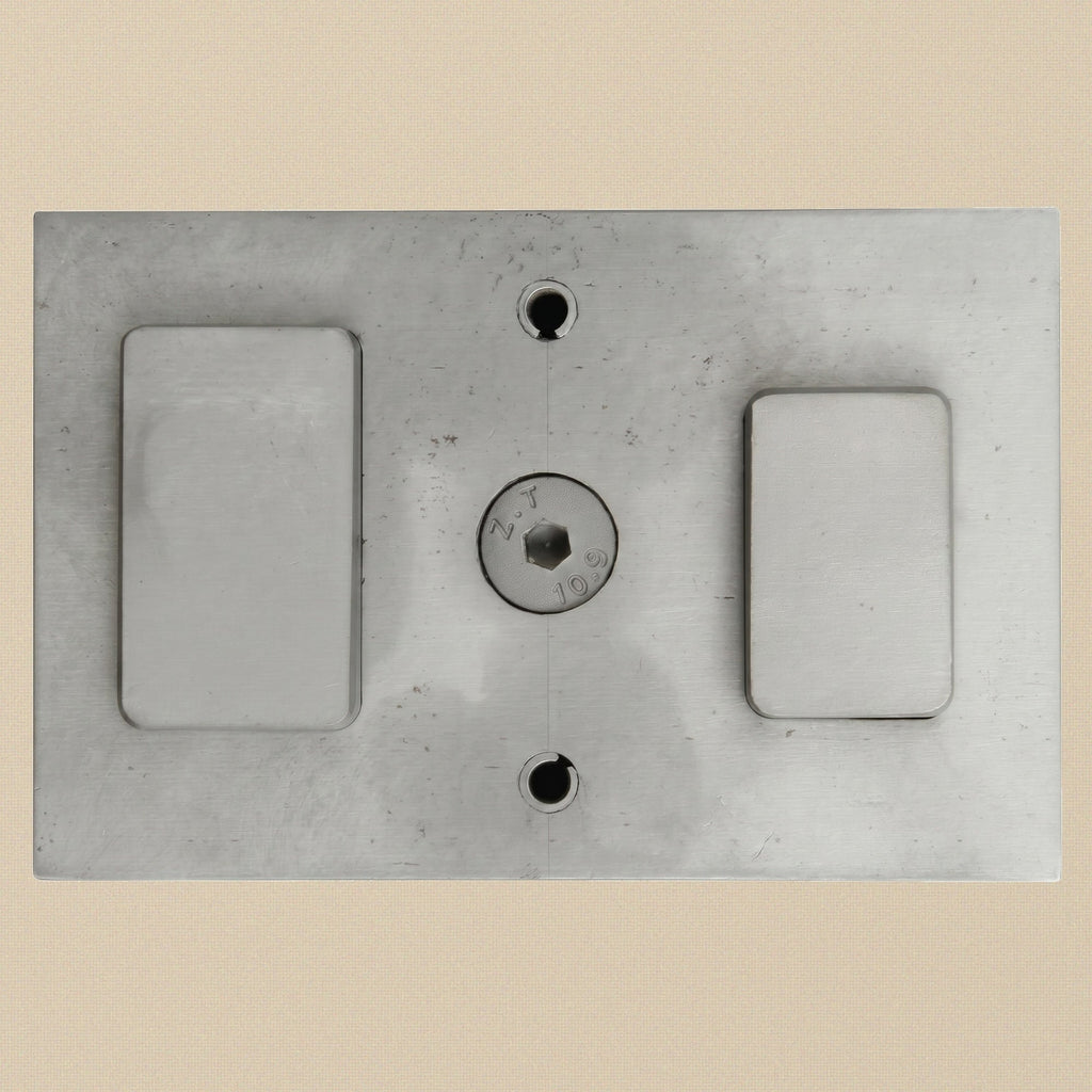 Close-up of the smaller 22 x 34.75 mm punch slot on the steel die block.