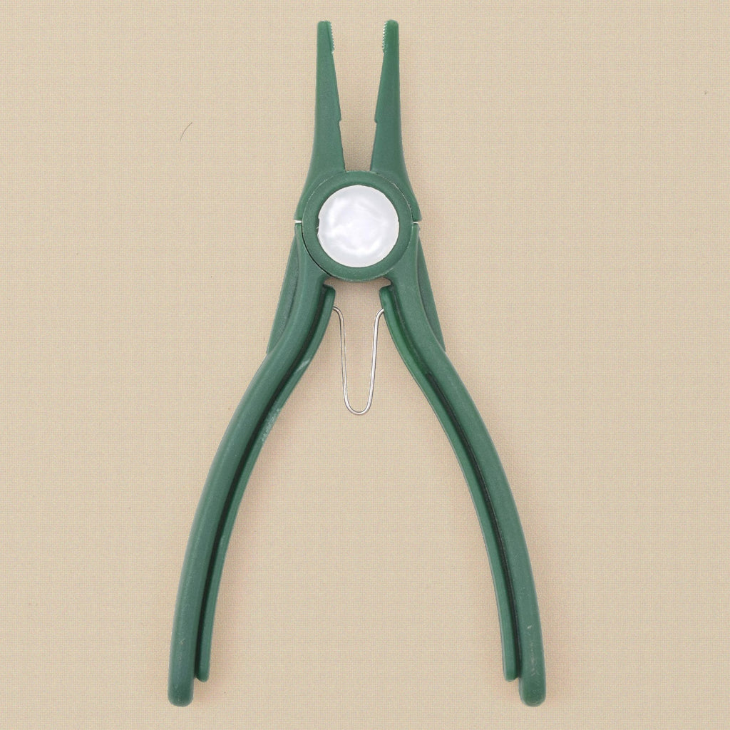 Green plastic chain nose pliers standing, jaws upward