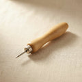 Steel watch band pin pusher with wooden handle, sharp point for watch repair.
