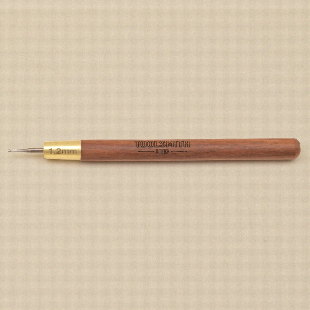 Wire rounder lying flat showing the wooden handle and brass ferrule