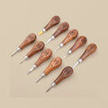 Ten stone setting tools with wooden handles laid out in two rows