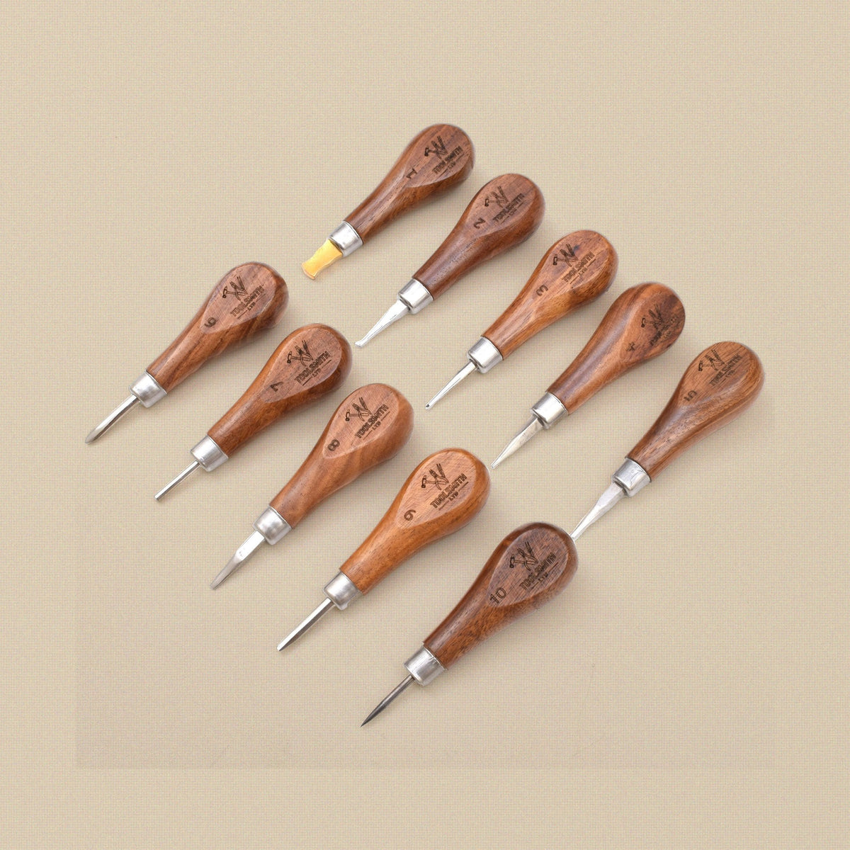 Ten stone setting tools with wooden handles laid out in two rows