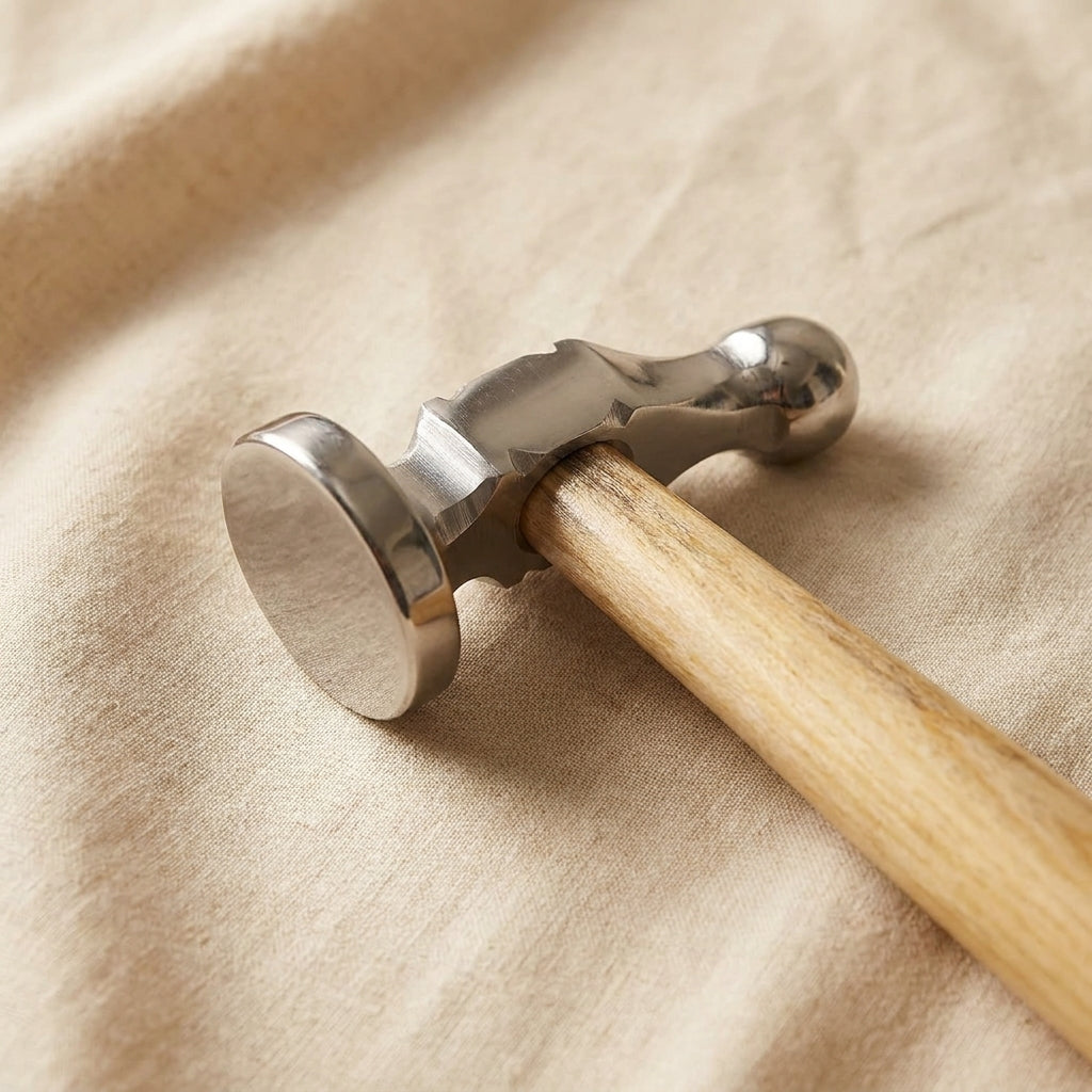 Close-up of the hammer head showing the polished bow face and ball peen for metal shaping