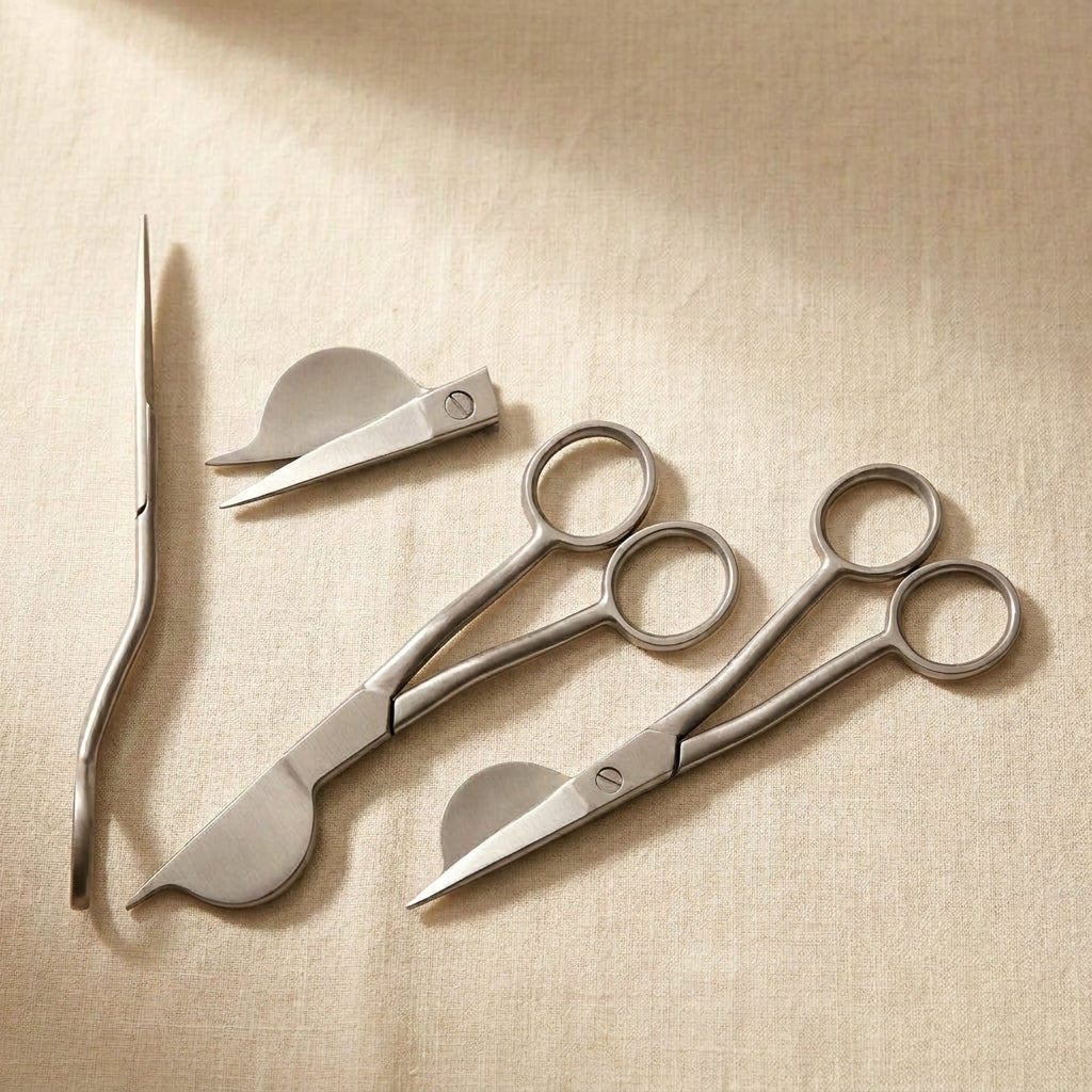 Curved half-duckbill appliqué scissors with offset handle for precise fabric cutting.