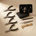 7-piece jewellery making tool set including pliers, tweezers and calipers in a black case