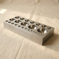 Hardened steel dapping block with 27 half-sphere depressions for jewellery forming, 130mm x 64mm.