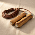 Leather skipping rope with polished wooden handles, adjustable for gym workouts