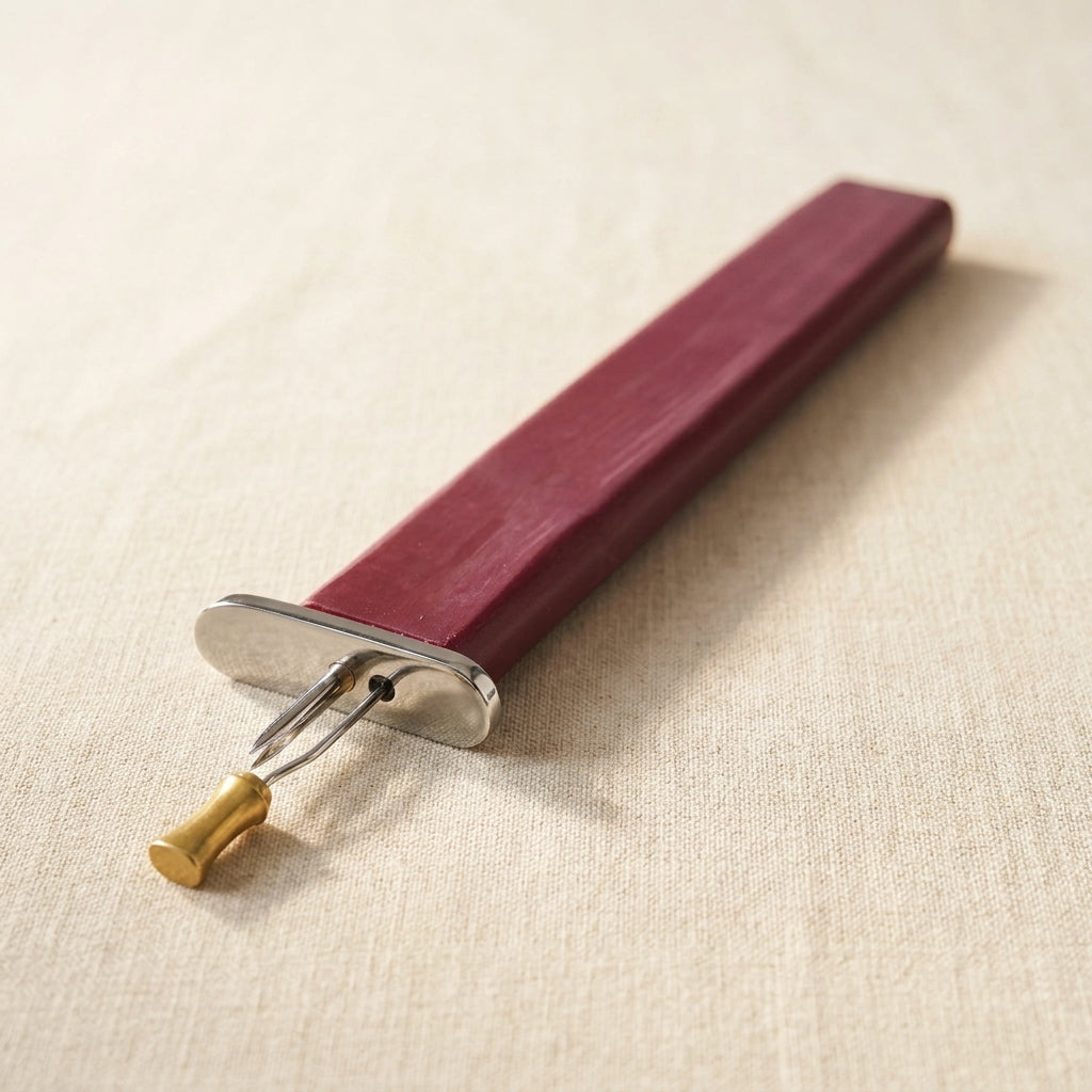 Maroon beading knotting tool for consistent knots, with a polished anodised finish.