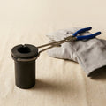Professional jewellery casting kit: graphite crucible, metal tongs, and leather protective gloves.