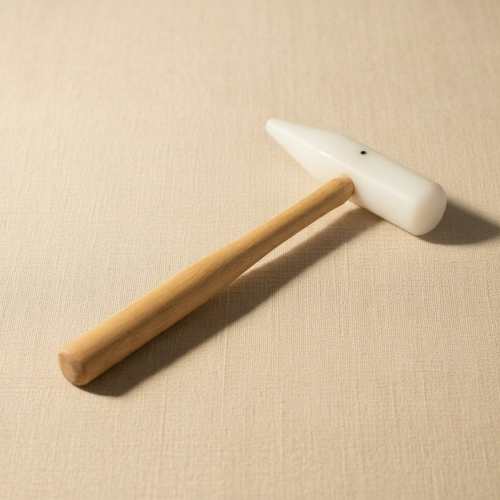 Jewellery forming mallet with round and cone Teflon heads and wooden handle for shaping metal.