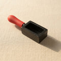 Cast iron ingot mould for melting gold and silver, featuring a red handle and 70mm x 35mm x 27mm dimensions.