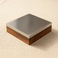 Steel bench block with wooden base, 4x4 inch, for jewellery forging and dapping.