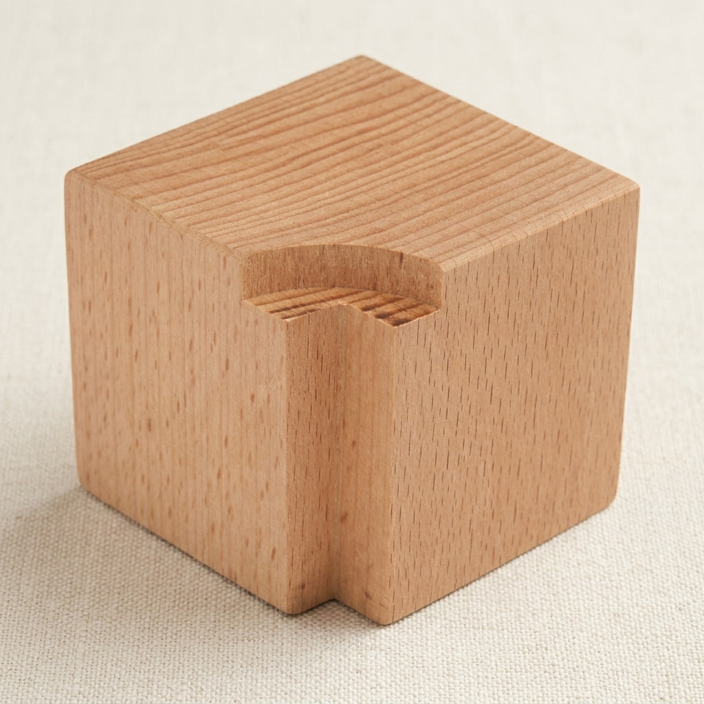 Wooden block for holding jewellery stamps securely during metal marking.